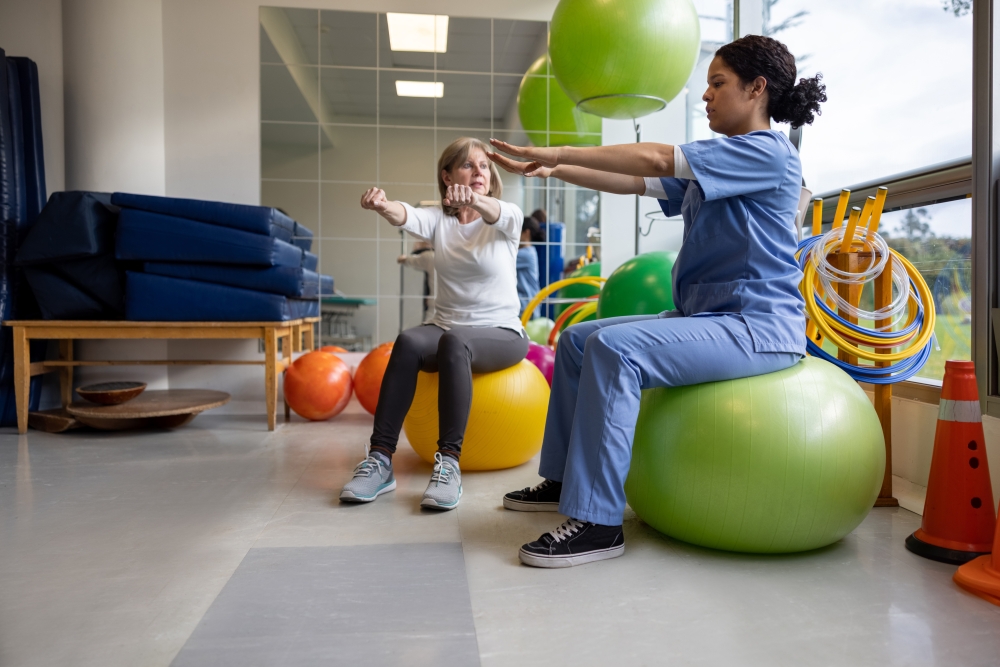 Physical therapist showing a woman an exercise for her recovery