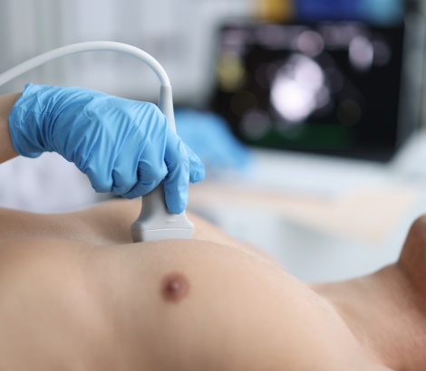 Doctor performs chest ultrasound on man in hospital closeup